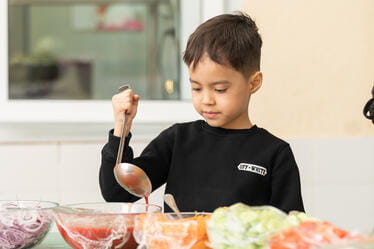 A student with bowls of liquid and a ladle
