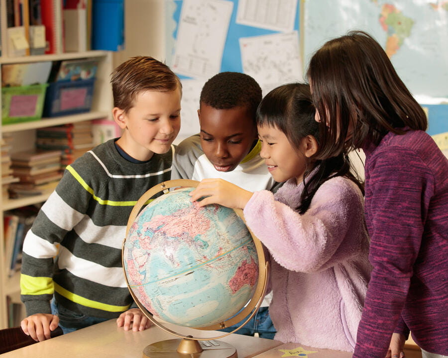 Group of students stood around a globe