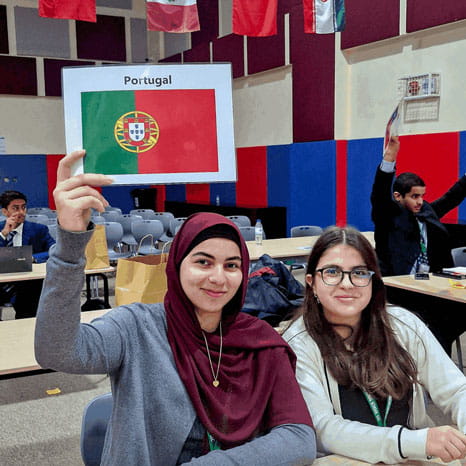 Girl student holds up Portugal flag in language class