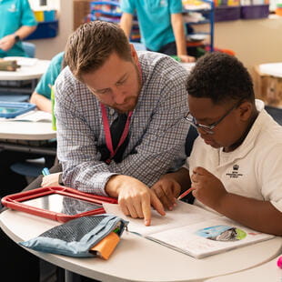 BISC South Loop teacher helping primary school student