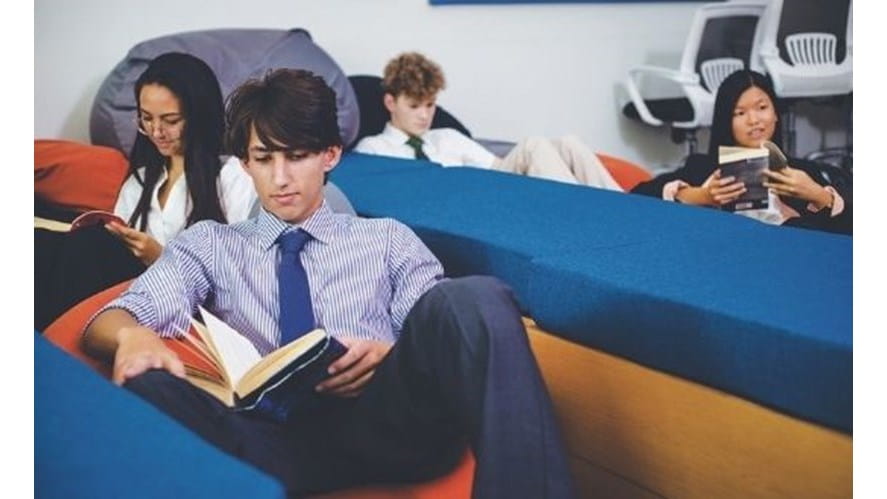 Student sitting down reading a book