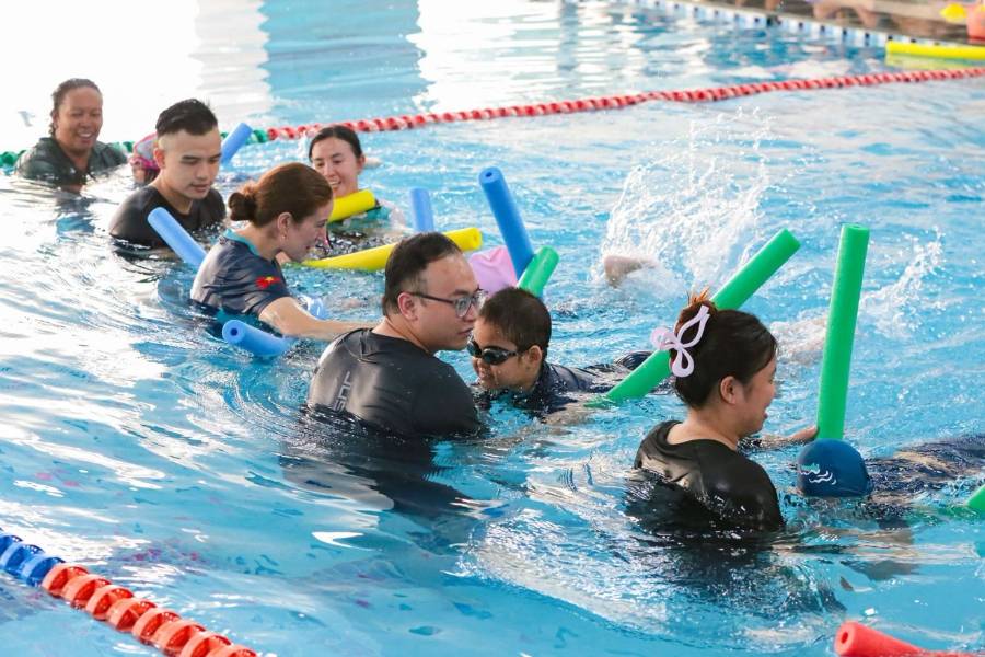 Teacher supporting students during a swimming lesson