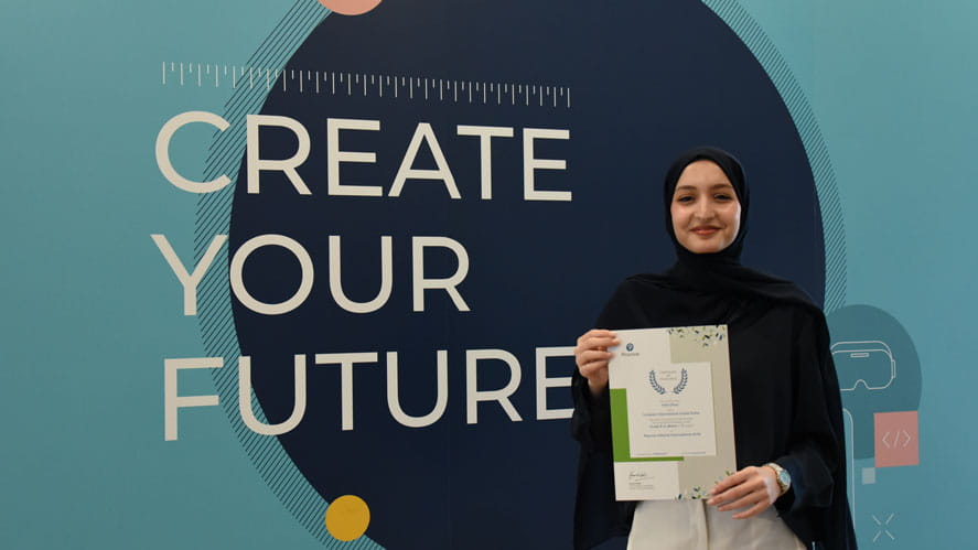 Student standing with Pearson Award at Compass International School Doha