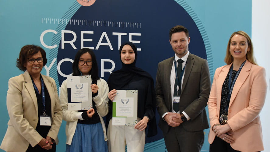 Two students standing with senior leadership receiving GCSE awards