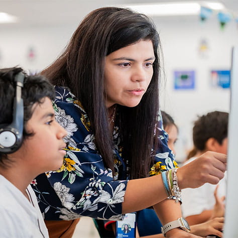 Student with teacher in technology classroom