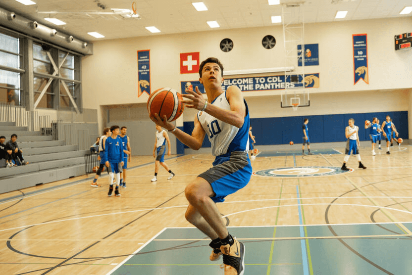 Student athlete playing basketball in the CDL gym, building teamwork and fitness through sport.