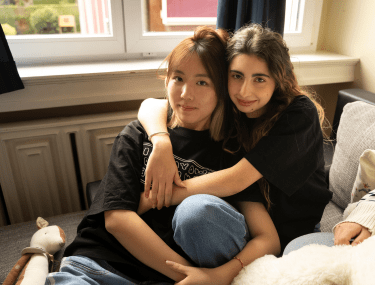 Two boarding students sharing a warm hug in their residence, reflecting friendship and emotional support at CDL.