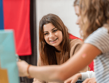 Boarding student smiling during a collaborative classroom activity, reflecting engagement and joy in learning at CDL.