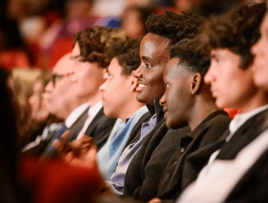 Boarding students attending a school event, immersed in a diverse, inspiring community atmosphere.