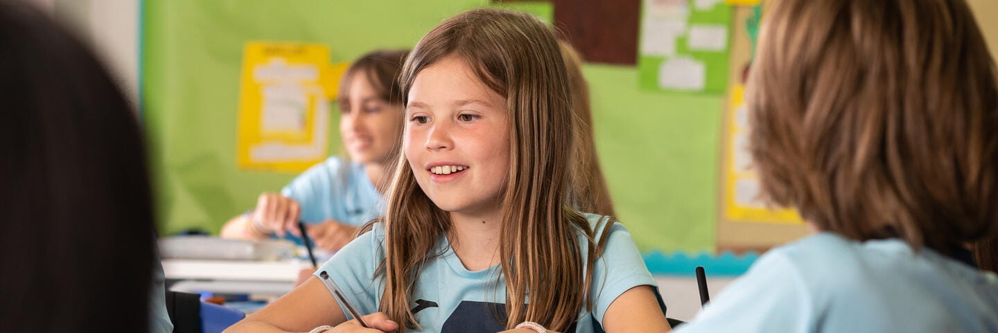 Foreign Languages International School in Madrid | ICS-Content Page Header-Girl smiling at desk