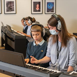 Young student learning piano with teacher - Nord Anglia Education
