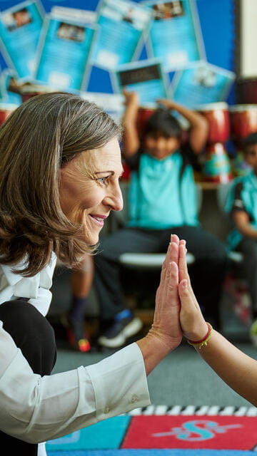 A teacher giving high-five to a primary student