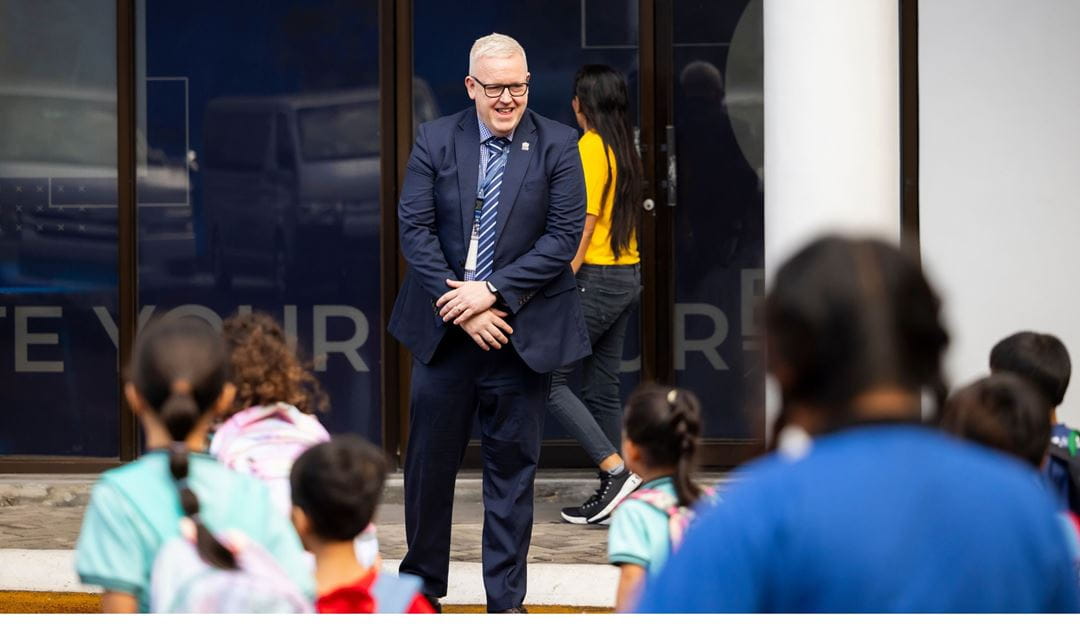 chris pooley welcoming students at NAIS Manila