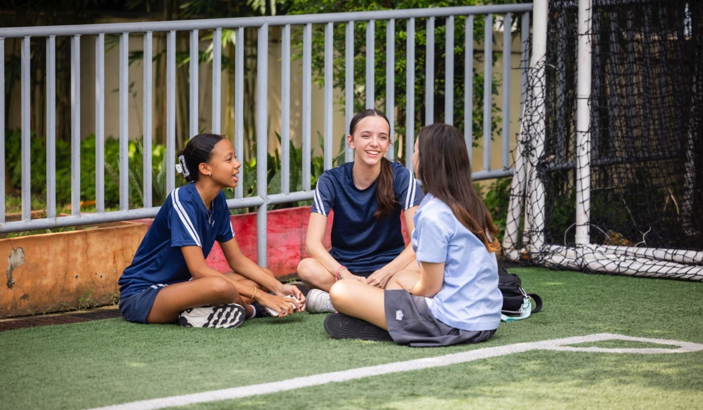 happy secondary students in the football field