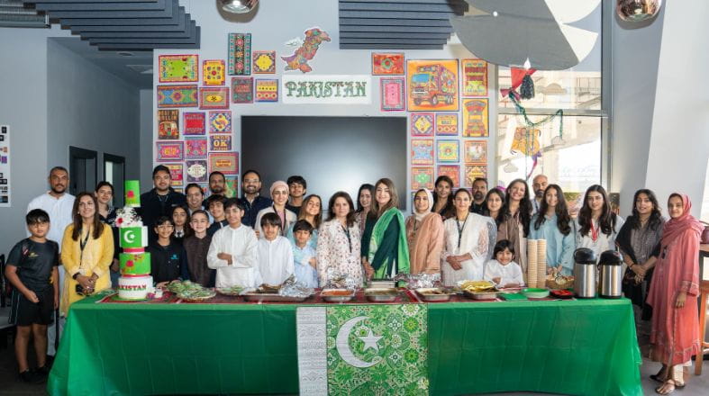 Parents and children celebrating Pakistan Day at NAS Dubai with Pakistani food, art and music.