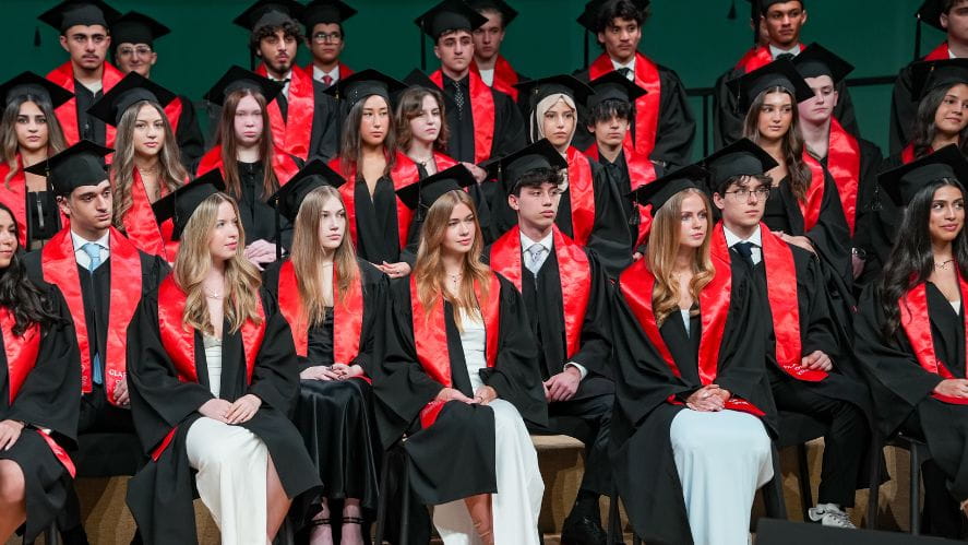 Graduating students in caps and gowns on stage