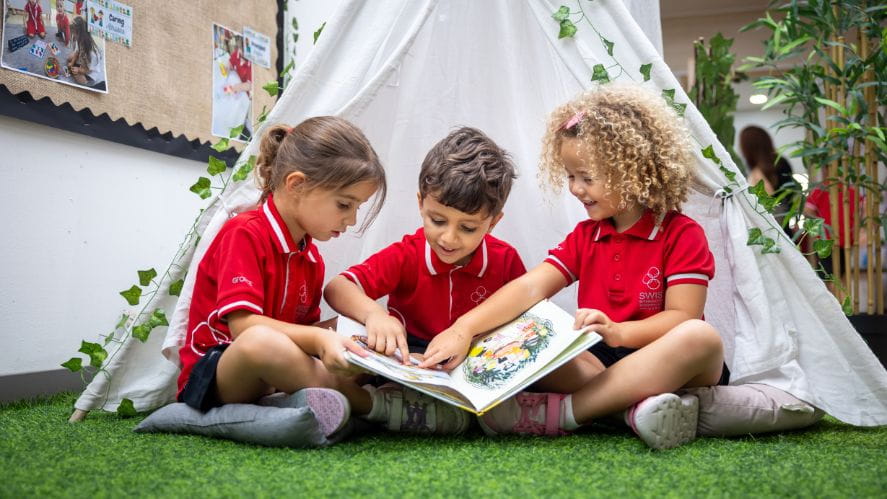 three students reading a book