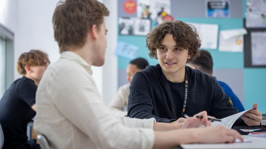 two students talking in classroom
