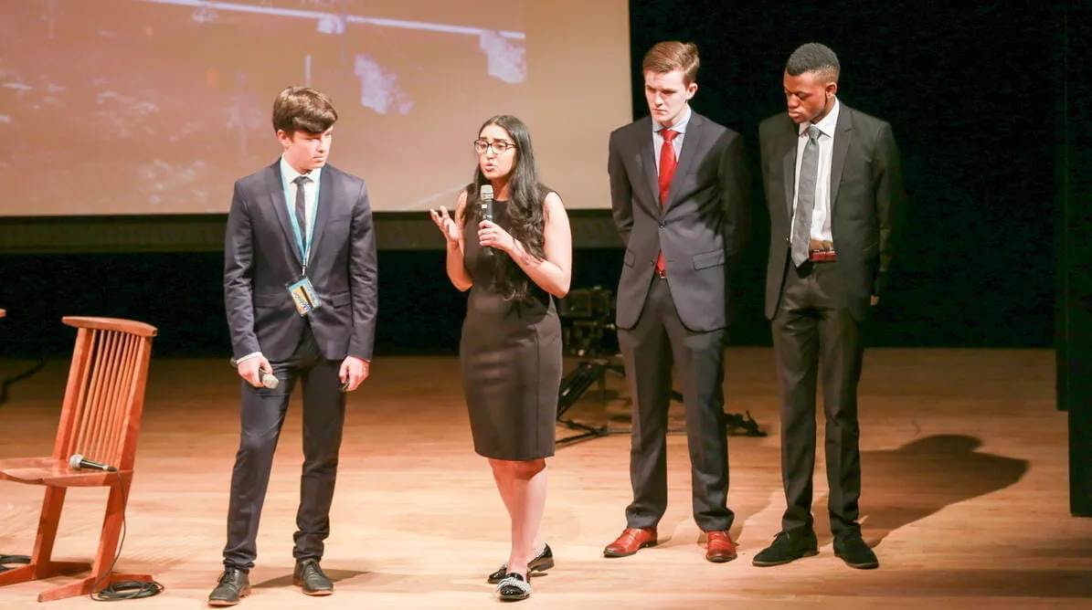 Student speaking on stage at a Model UN event