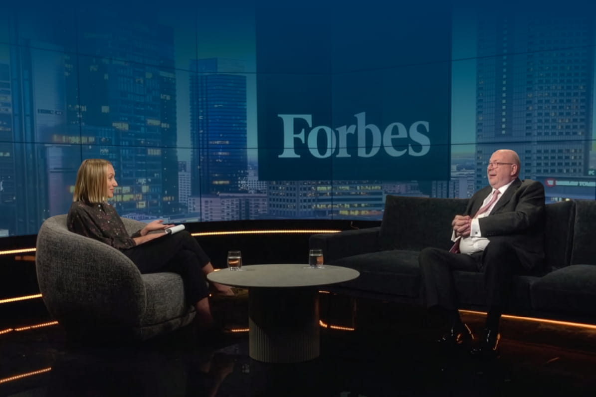 a principal and a Forbes interviewer in a studio