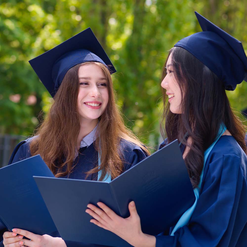 two IB students with their diplomas