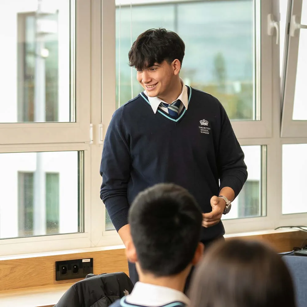 student talking with a group by a window