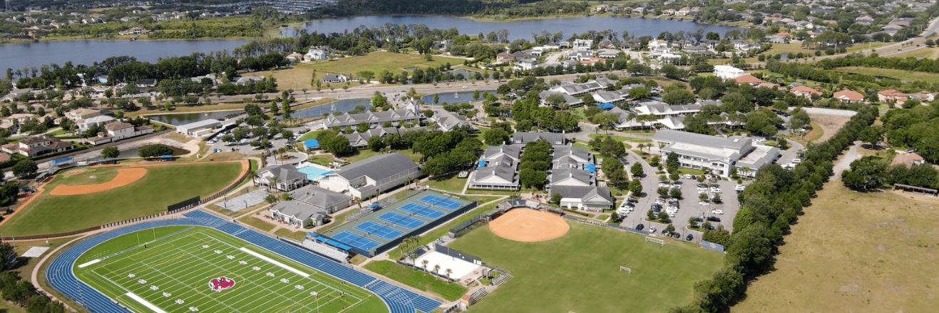 Aerial view of Windermere Preparatory School campus featuring athletic fields, tennis courts, academic buildings, and surrounding residential areas near Lake Butler.