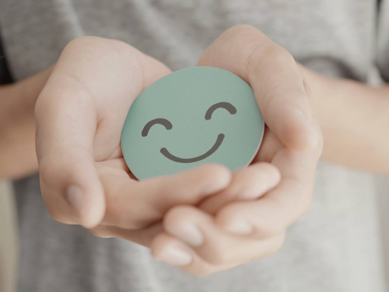 How you can support your childs mental health-How you can support your childs mental health-hands-in-a-heart-shape-holding-a-paper-smiley-face (1)