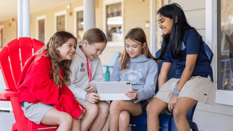 Windermere Prep lower school students working together on a tablet outside on campus.